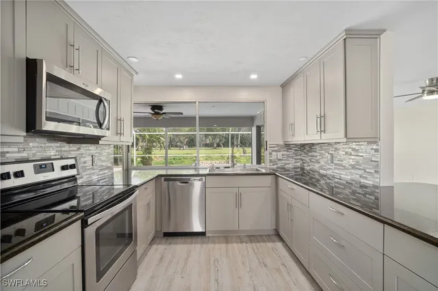 a kitchen with stainless steel appliances granite countertop a sink and stove top oven
