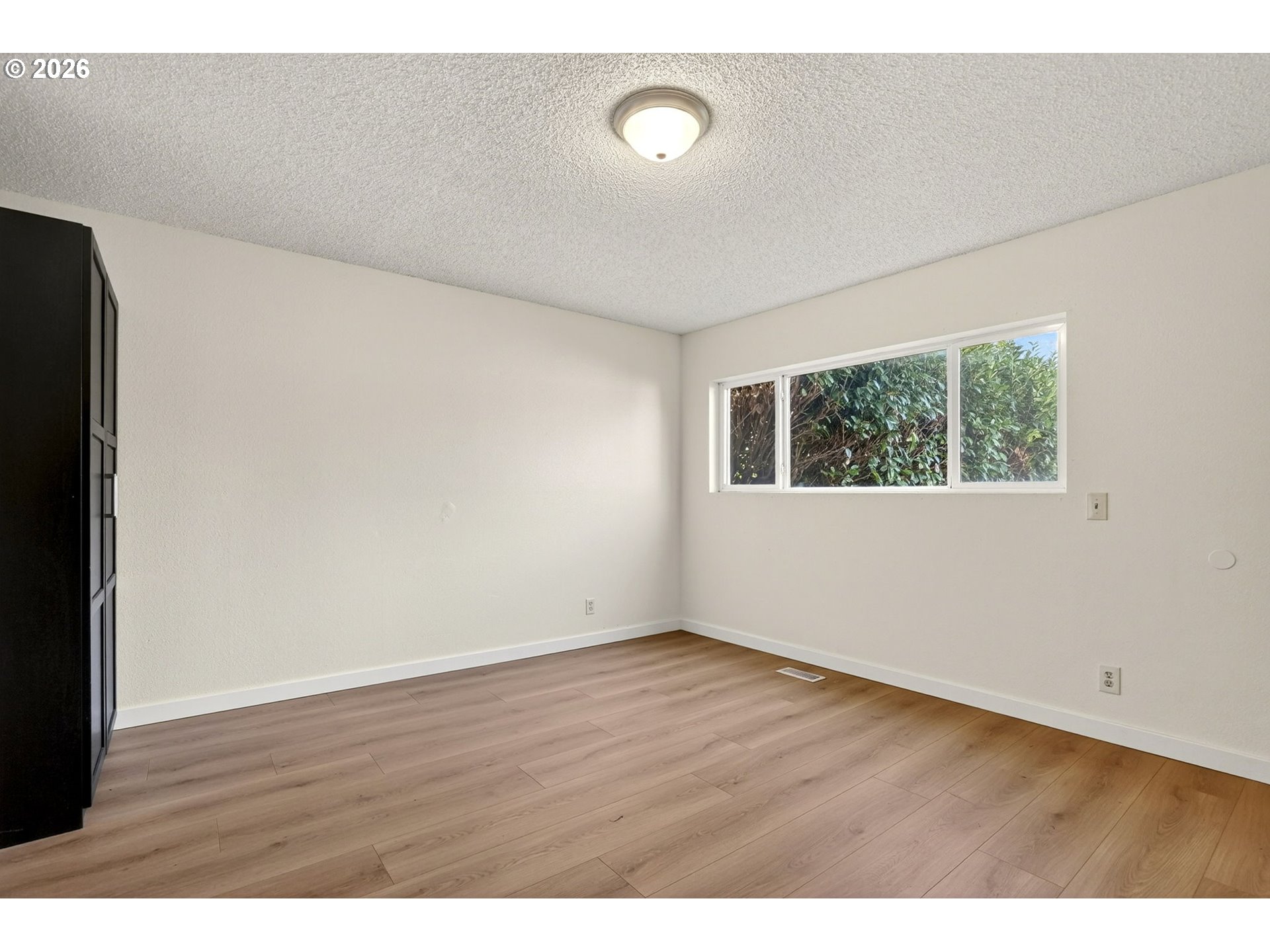 5249 Northeast 45th Place Portland, OR 97218 - Photo 17 of 48 a view of an empty room with wooden floor and a window