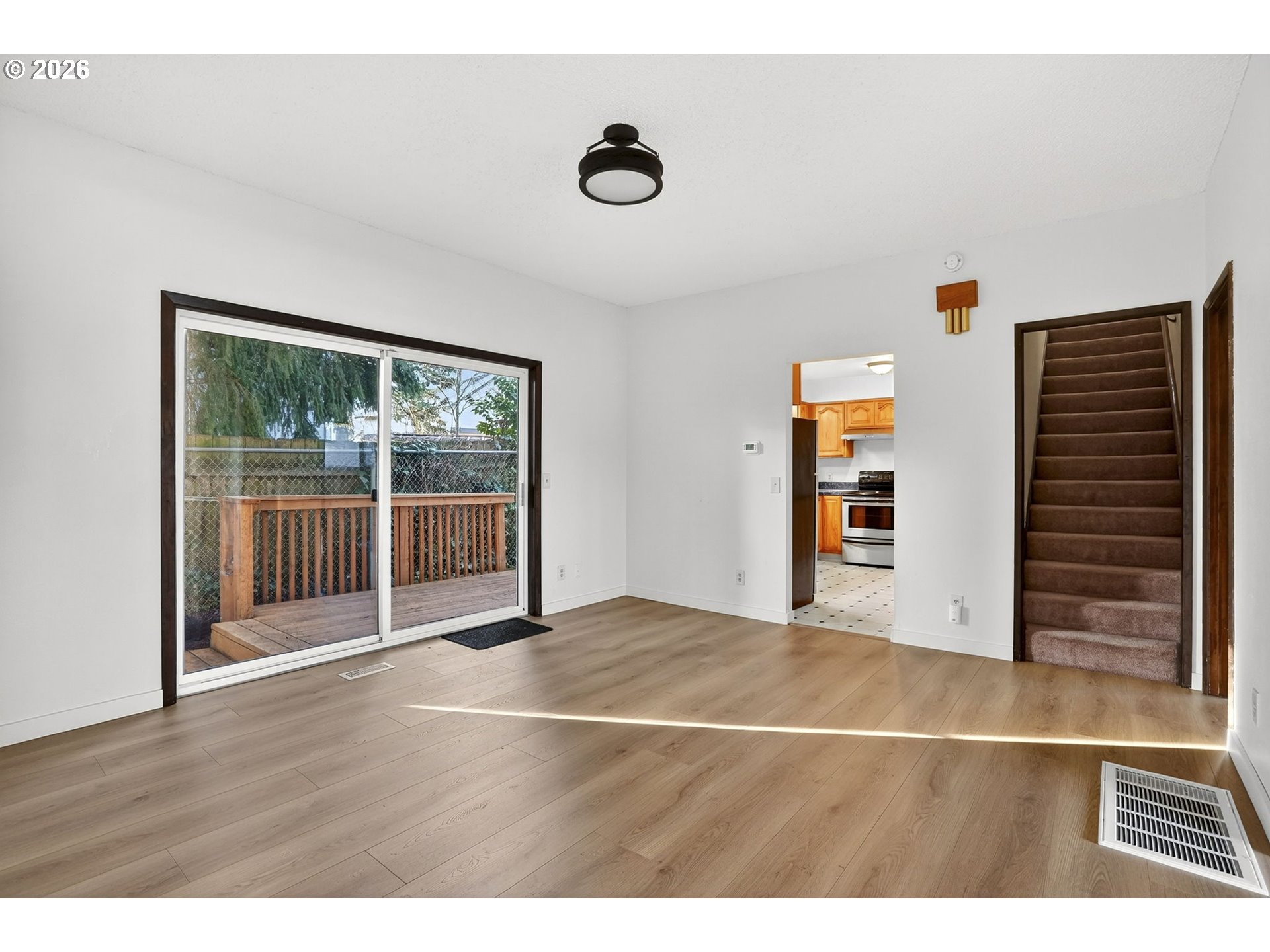 5249 Northeast 45th Place Portland, OR 97218 - Photo 7 of 48 a view of an empty room with wooden floor and a window