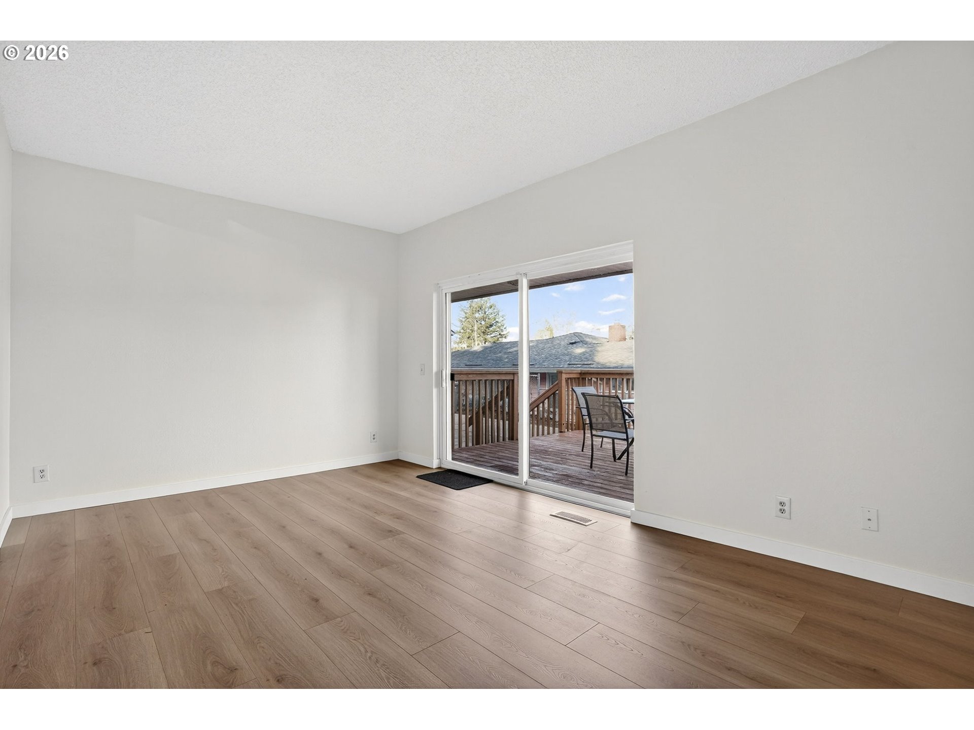 5249 Northeast 45th Place Portland, OR 97218 - Photo 10 of 48 a view of an empty room with wooden floor and a window