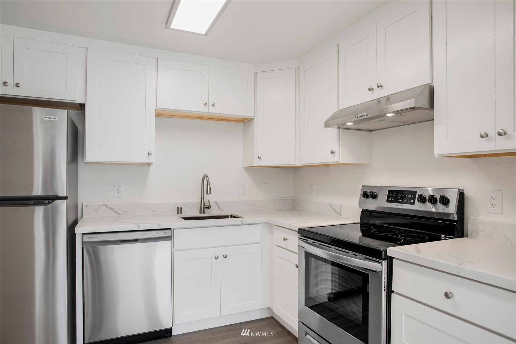 10201 17th Avenue Southwest Seattle, WA 98146 - Photo 19 of 25 a kitchen with stainless steel appliances white cabinets and a stove a refrigerator with white countertops