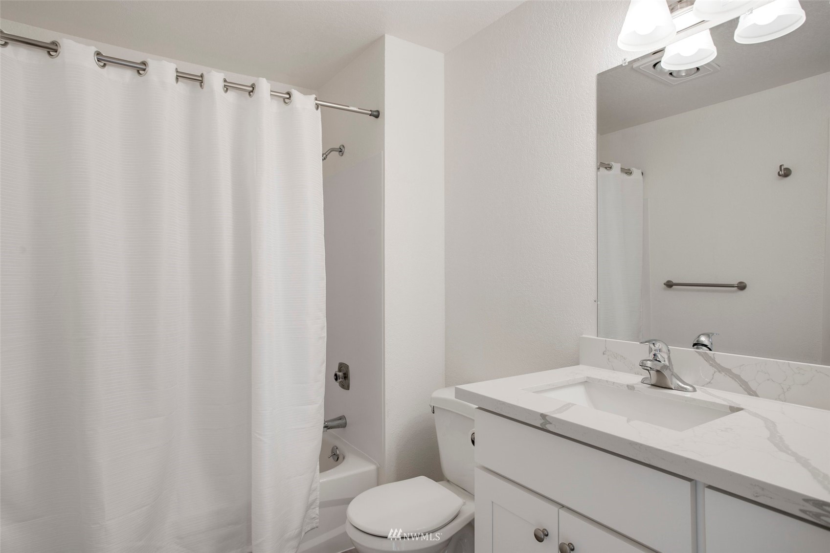 10201 17th Avenue Southwest Seattle, WA 98146 - Photo 22 of 25 a bathroom with a sink a toilet and shower curtain