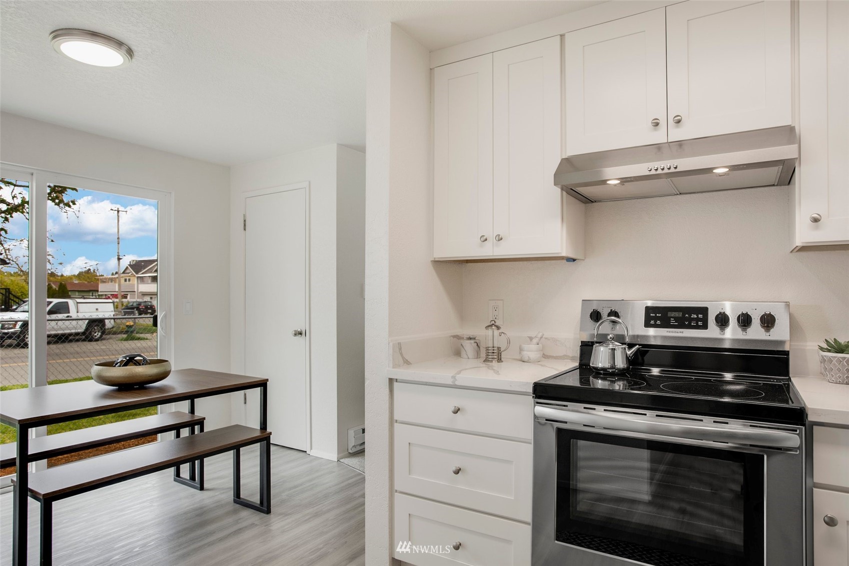 10201 17th Avenue Southwest Seattle, WA 98146 - Photo 7 of 25 a kitchen with a stove and white cabinets