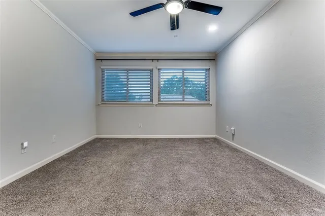 en empty room with windows and ceiling fan