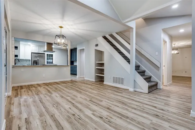 a view of a livingroom with wooden floor and stairs