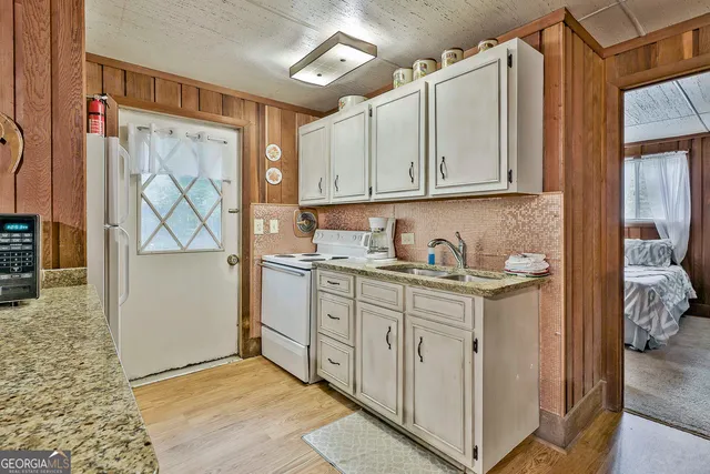 a kitchen with stainless steel appliances granite countertop a sink and a refrigerator