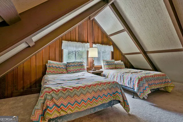 a bedroom with two beds and wooden floor