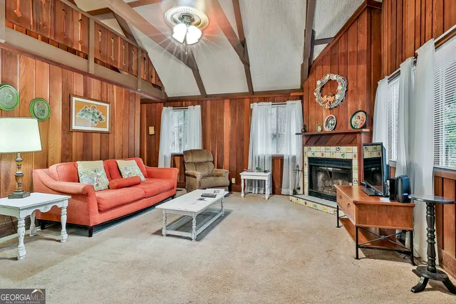 a living room with furniture a fireplace and a large window
