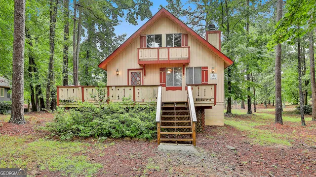 a view of a house with backyard and trees