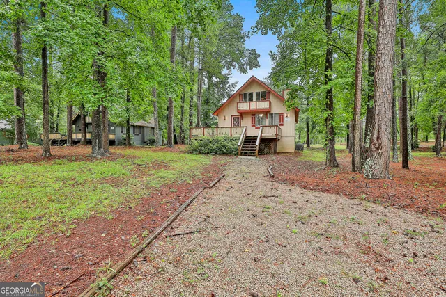 a front view of a house with a yard and trees