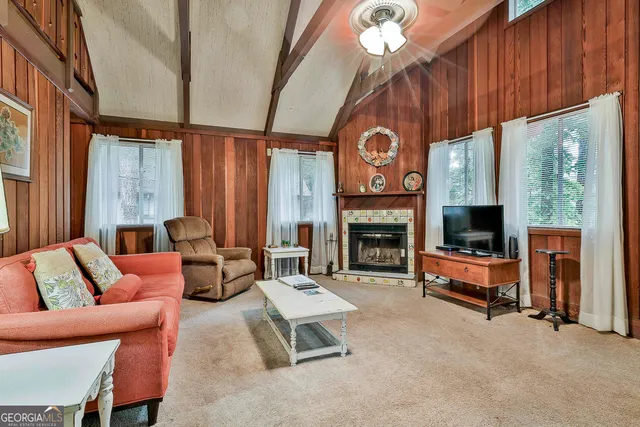 a living room with furniture a fireplace and a large window