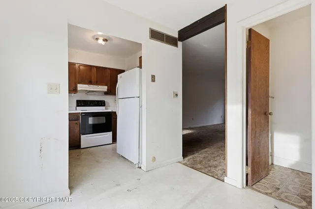a view of kitchen with refrigerator and stove