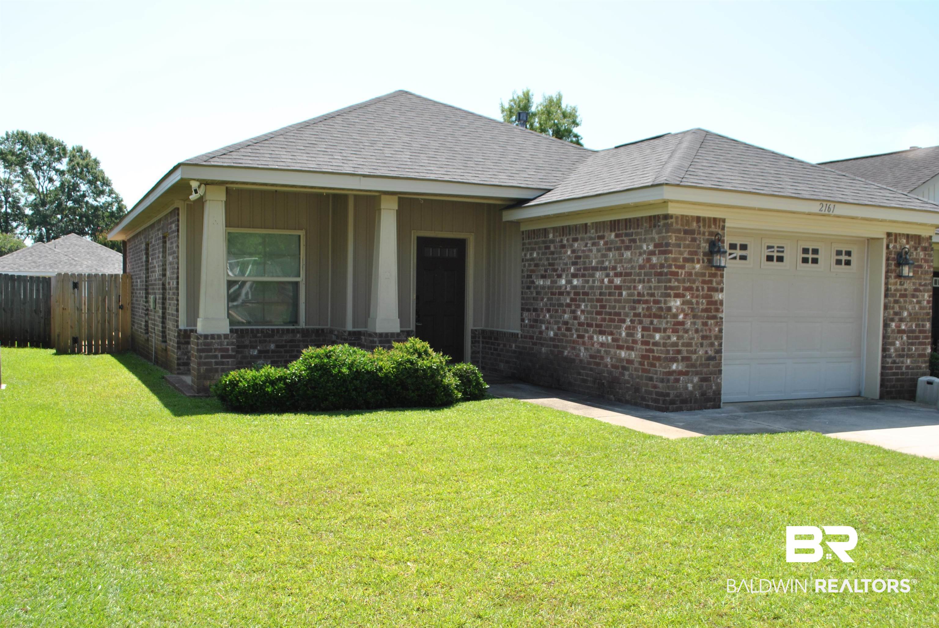 2161 Spring Grove West Mobile, AL 36695 - Photo 5 of 31 View of front facade with brick siding, a garage, concrete driveway, and roof with shingles