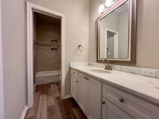 a en suite bathroom with a granite countertop sink and a mirror
