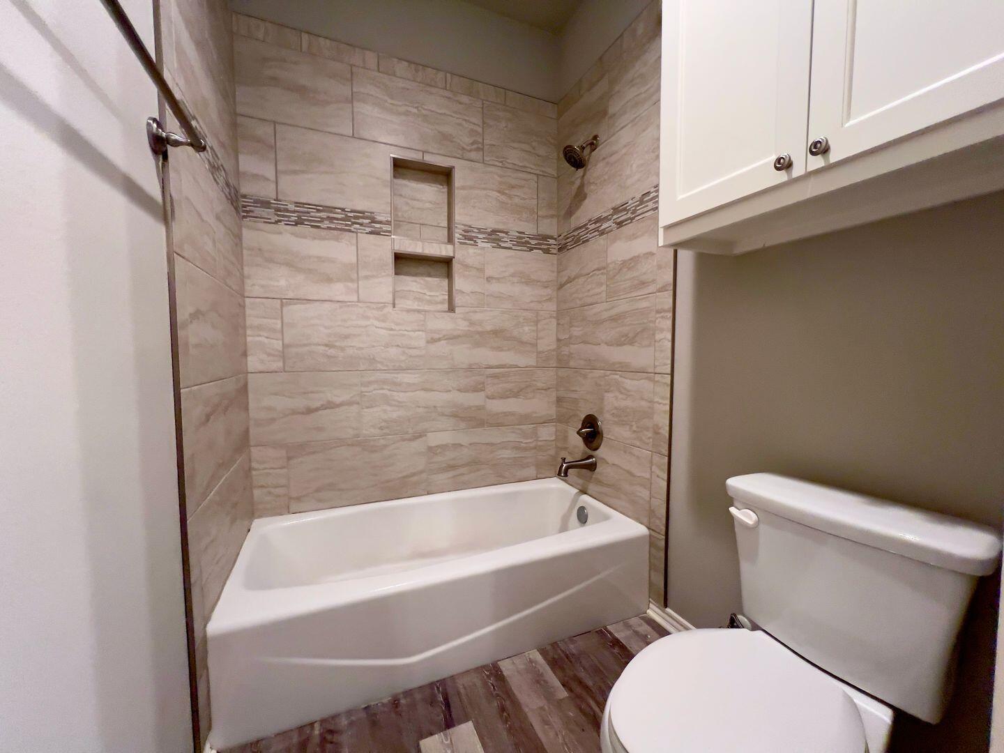 7817 57th Street Lubbock, TX 79407 - Photo 16 of 21 a white toilet sitting next to a bath tub