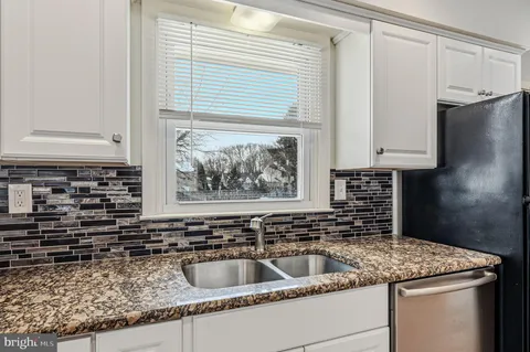 a kitchen with granite countertop a sink and a stove