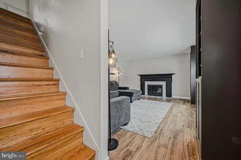 a view of a livingroom with wooden floor and a fireplace