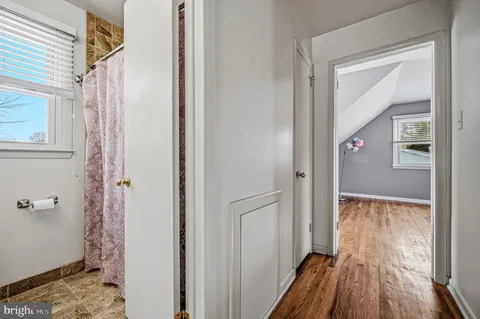 a view of a bedroom with wooden floor and a window