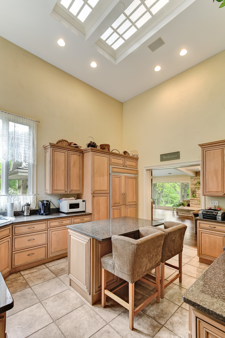 3500 Spring Road Oak Brook, IL 60523 - Photo 23 of 44 a kitchen with stainless steel appliances kitchen island granite countertop a table chairs sink and cabinets
