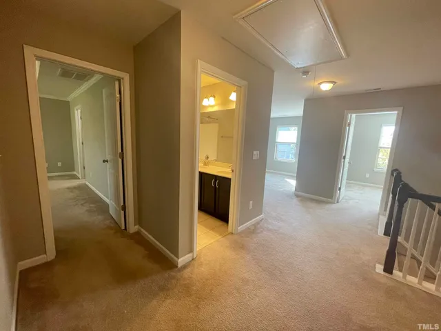 an empty room with a bathroom and mirror