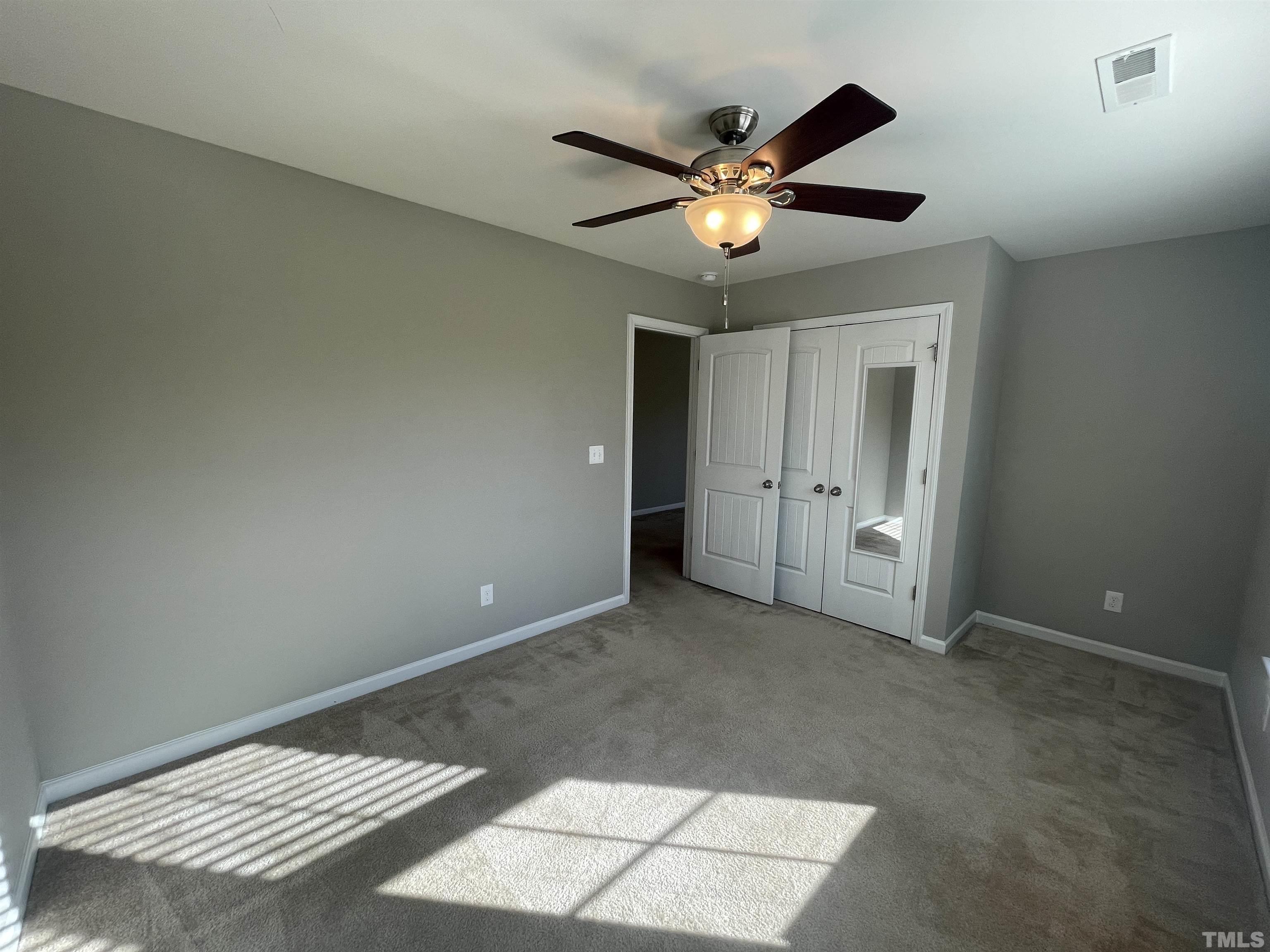 3928 Valley Side Court Cary, NC 27519 - Photo 14 of 26 an empty room with closet and a chandelier fan