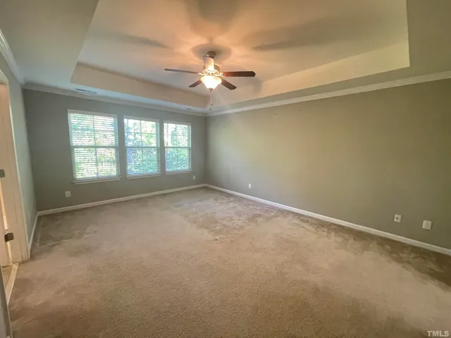 an empty room with a ceiling fan and a window