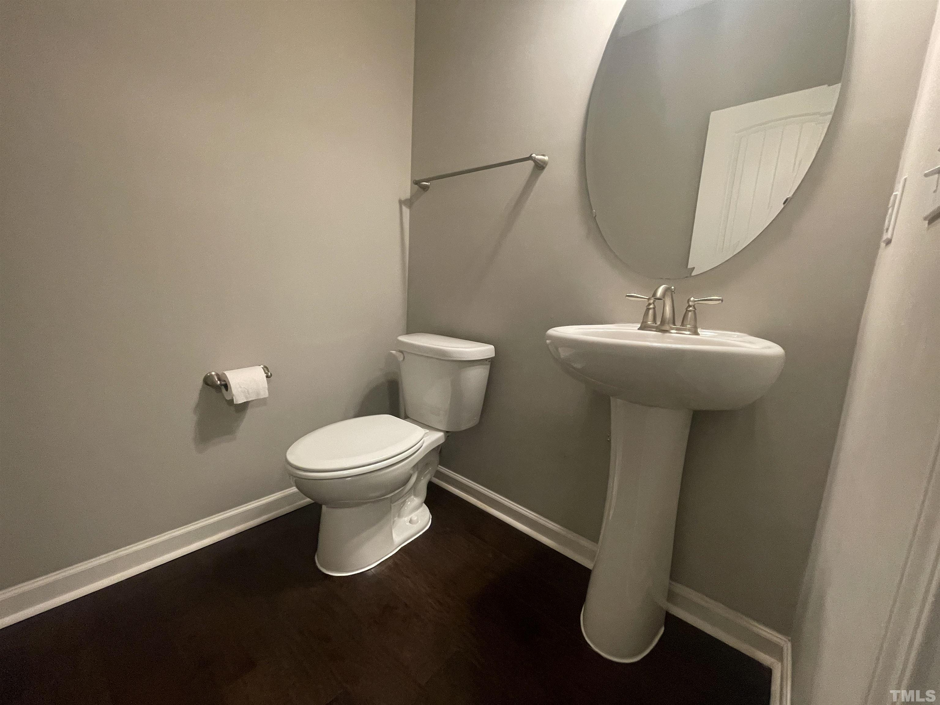 3928 Valley Side Court Cary, NC 27519 - Photo 9 of 26 a bathroom with a toilet a sink and a mirror
