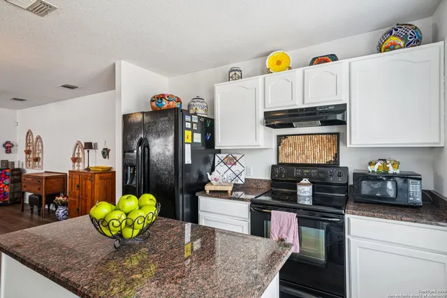 a kitchen with a sink a counter and chairs