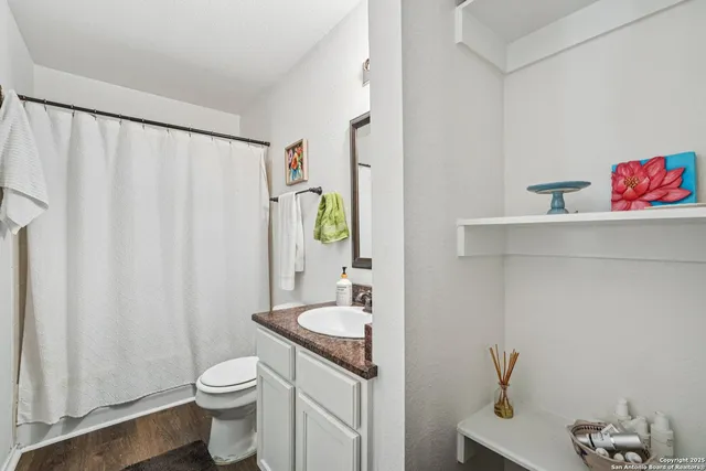 a bathroom with a sink vanity mirror and toilet