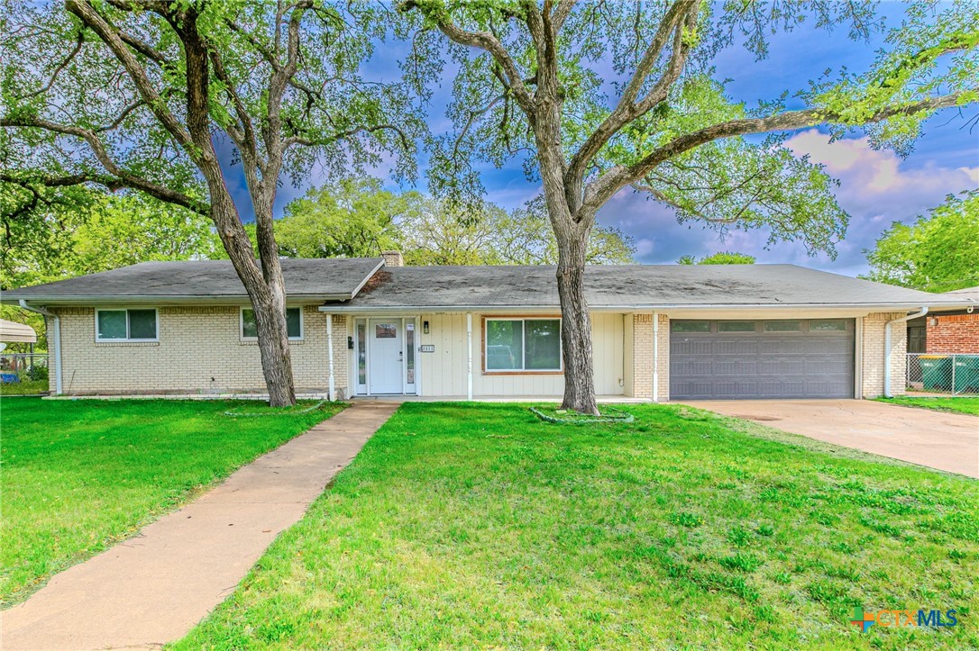 Front exterior view of home with mature trees and spacious front yard