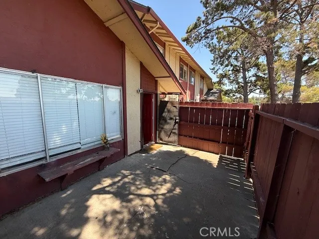 a view of backyard with wooden fence and large trees
