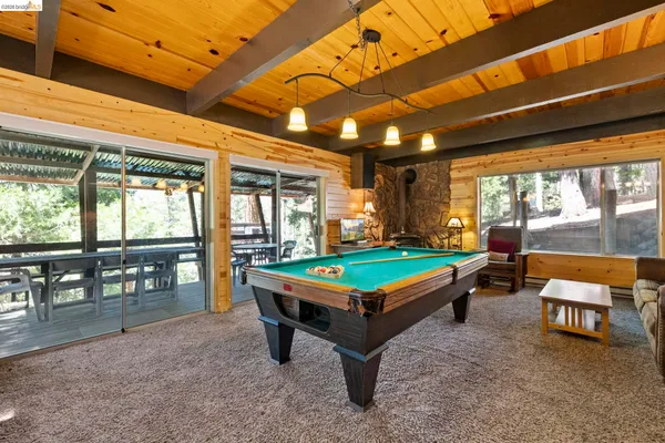 a room with pool table and glass windows
