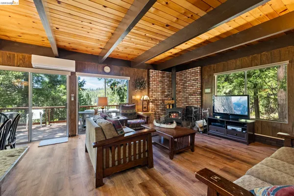 a living room with furniture a flat screen tv and floor to ceiling windows