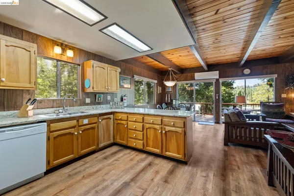 a kitchen with stainless steel appliances granite countertop wooden floors and white cabinets