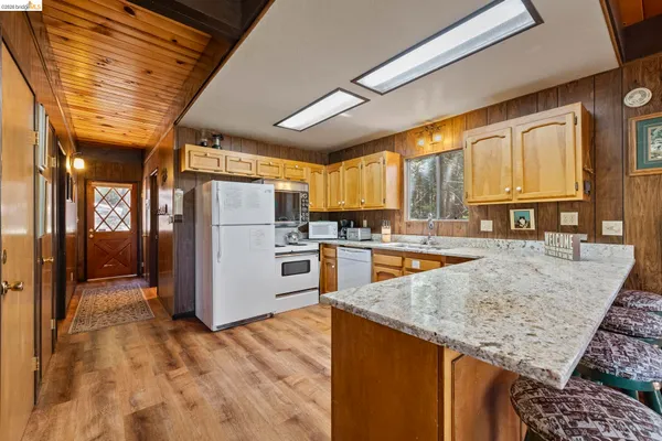 a kitchen with stainless steel appliances granite countertop a refrigerator a oven and a sink