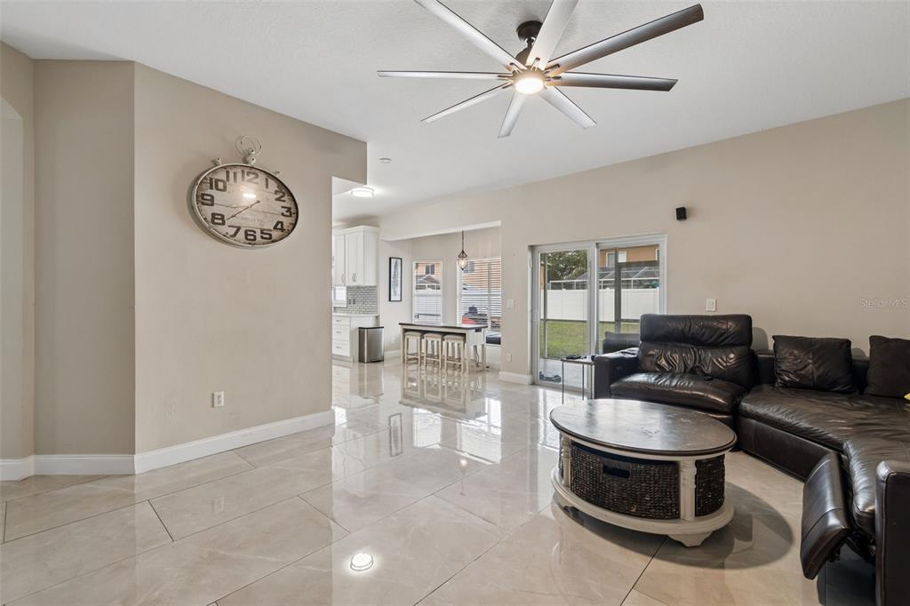 2829 Pankaw Lane Valrico, FL 33596 - Photo 22 of 55 a living room with furniture a clock and a ceiling fan