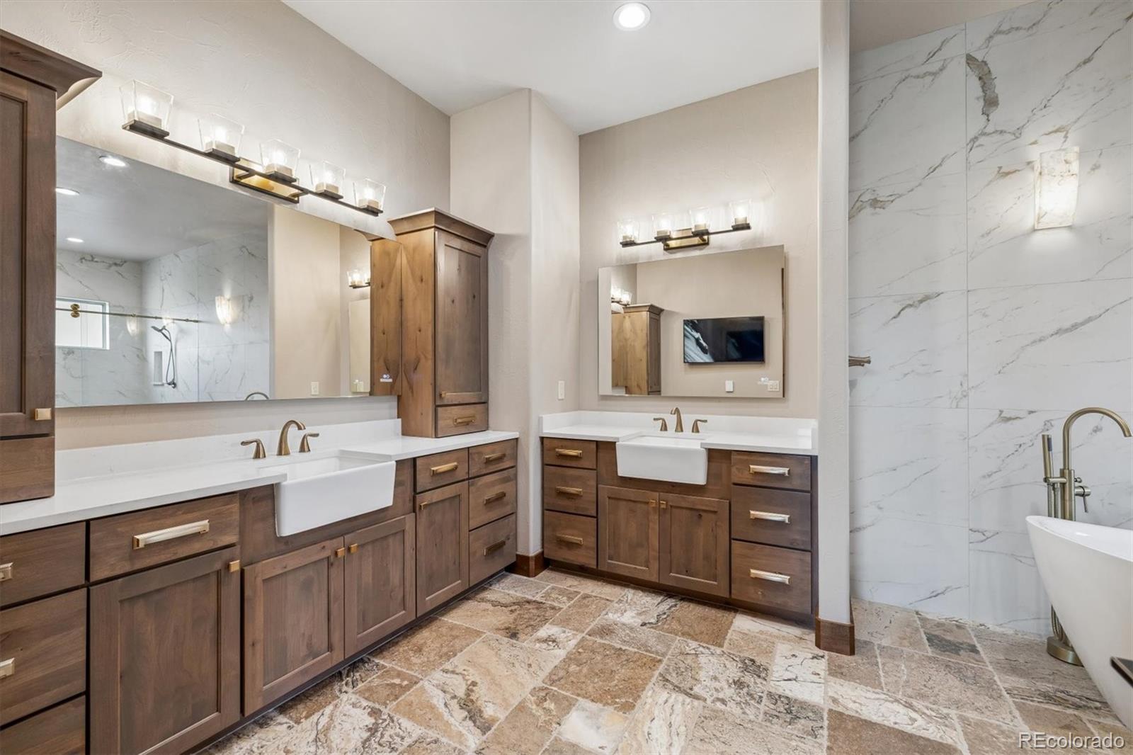 5754 Powell Road Parker, CO 80134 - Photo 20 of 43 a spacious bathroom with a bathtub sink double vanity and a mirror