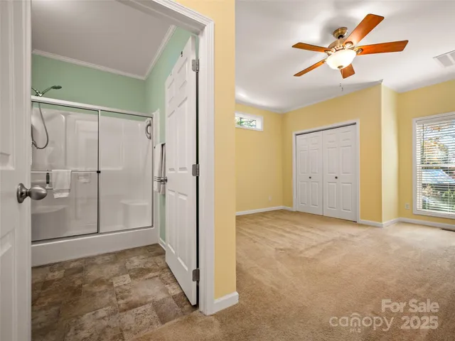 an empty room with closet and a ceiling fan