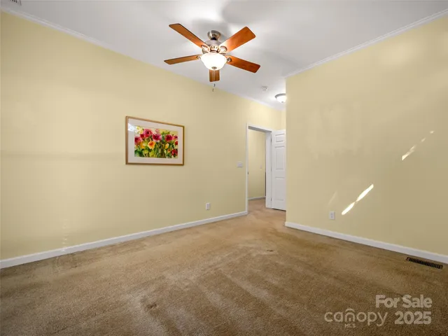 an empty room with ceiling fan and window