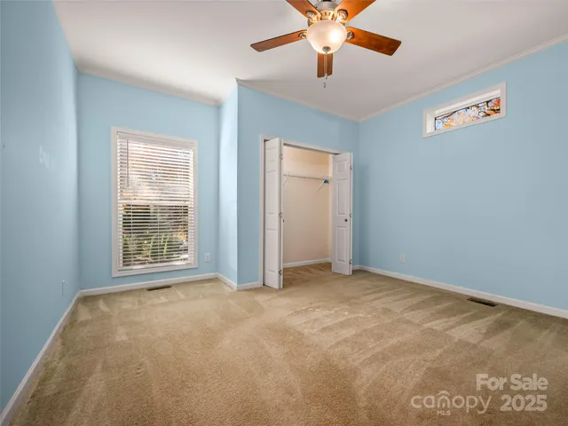 an empty room with a window and a ceiling fan