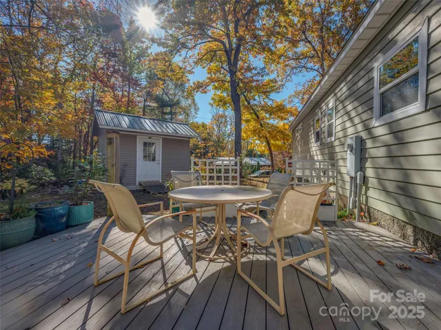 a view of a patio with table and chairs and potted plants with wooden floor and fence