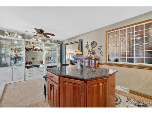 a dining hall with stainless steel appliances kitchen island granite countertop a table and chairs in it