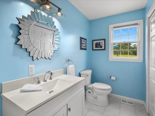 a bathroom with a toilet a sink and a mirror