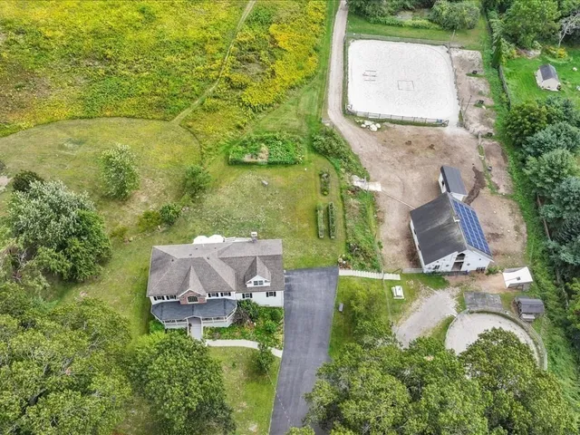 an aerial view of residential house with outdoor space and trees all around