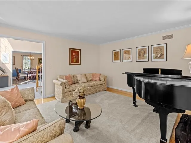 a living room with furniture a piano and a flat screen tv