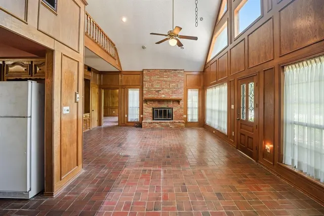 a view of an empty room with a fireplace and a window
