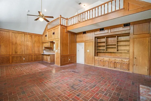 a kitchen with stainless steel appliances granite countertop a refrigerator a oven and white cabinets with wooden floors