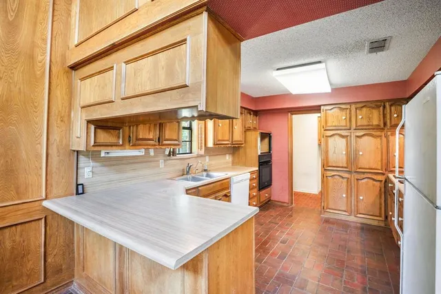 a bathroom with a granite countertop toilet and sink