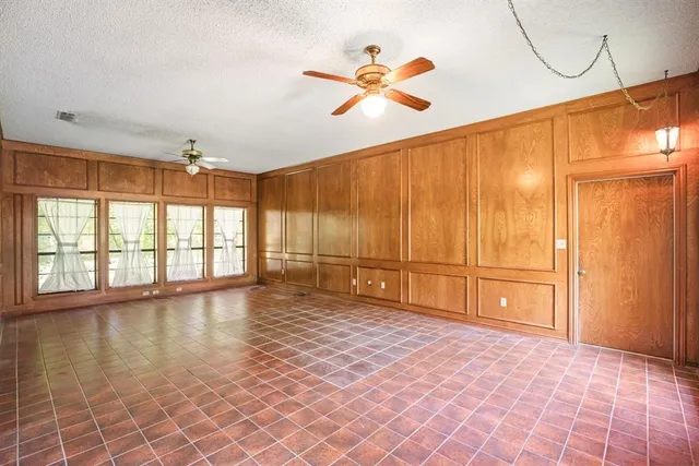 an empty room with closet and a chandelier fan