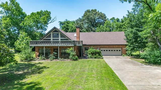 an aerial view of residential house with outdoor space and trees all around